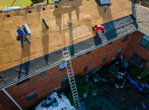 worker installing rubber roof before shingles